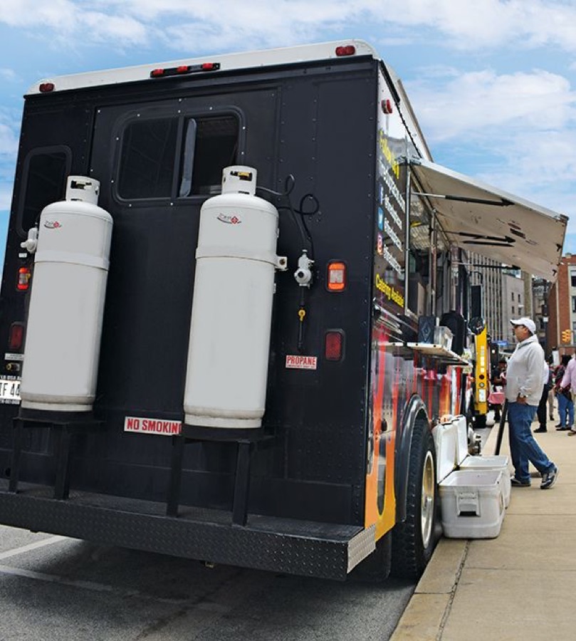 Food truck with propane tanks mounted on the back.